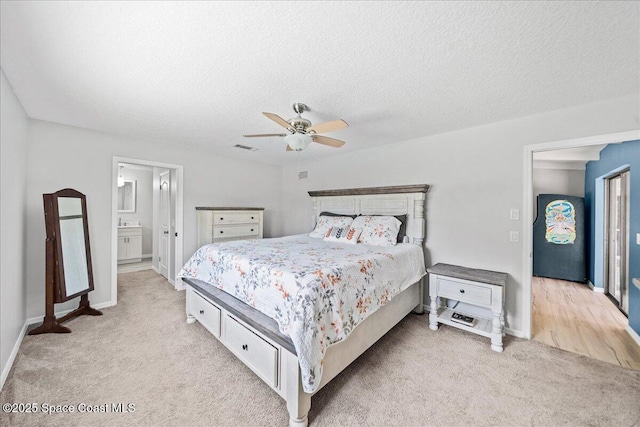 380 Cherry Ct, Satellite Beach, FL 32937 - bedroom with light colored carpet, a textured ceiling, ceiling fan, and connected bathroom
