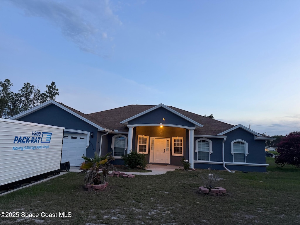 13350 SW 86th Ave SW, Ocala, FL 34473 - single story home featuring a garage, roof with shingles, a front yard, stucco siding, and covered porch