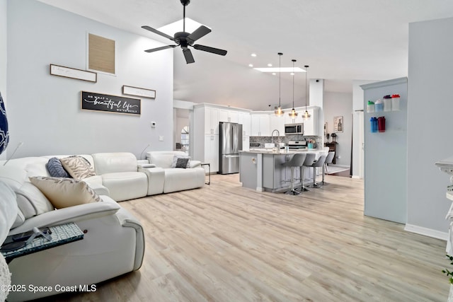 1276 Cypress Trace Dr, Melbourne, FL 32940 - living room with a ceiling fan, light wood-style flooring, and a high ceiling
