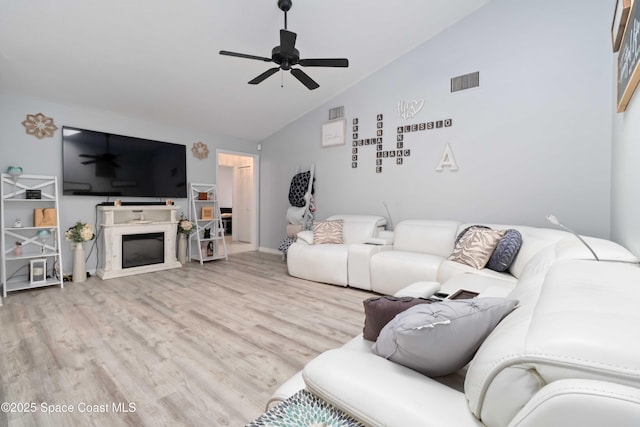 1276 Cypress Trace Dr, Melbourne, FL 32940 - living room featuring vaulted ceiling, ceiling fan, wood finished floors, and a fireplace