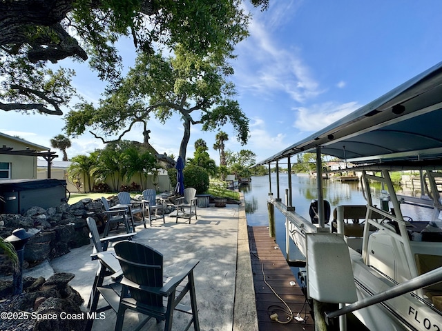 52 Riverview Ln, Cocoa Beach, FL 32931 - view of patio featuring a water view, a dock, boat lift, and a hot tub