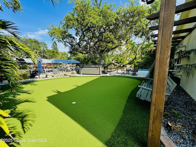 52 Riverview Ln, Cocoa Beach, FL 32931 - view of yard featuring an area to practice putting and a patio