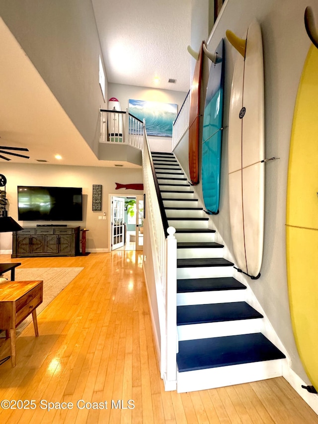 52 Riverview Ln, Cocoa Beach, FL 32931 - staircase with hardwood / wood-style flooring, a towering ceiling, and ceiling fan