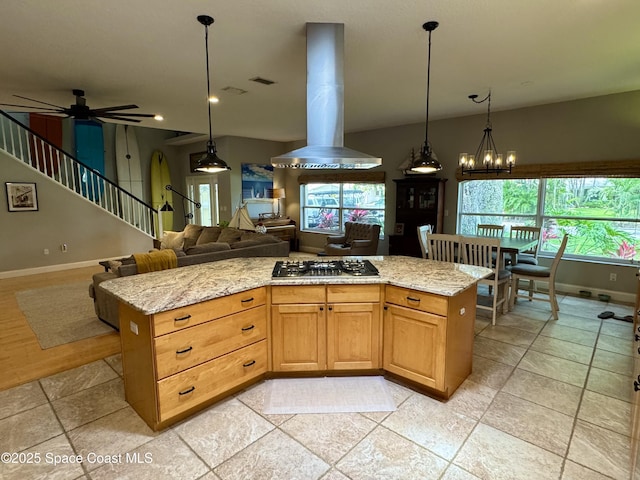 52 Riverview Ln, Cocoa Beach, FL 32931 - kitchen featuring stainless steel gas stovetop, island range hood, open floor plan, light stone counters, and hanging light fixtures