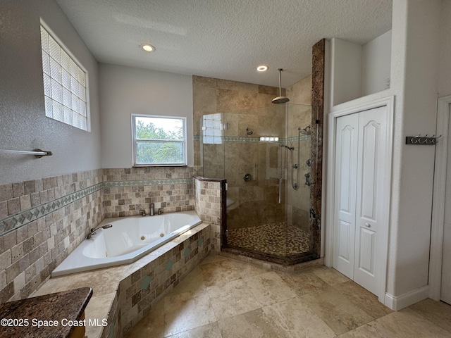 52 Riverview Ln, Cocoa Beach, FL 32931 - full bath with a tub with jets, a shower stall, a textured ceiling, and recessed lighting