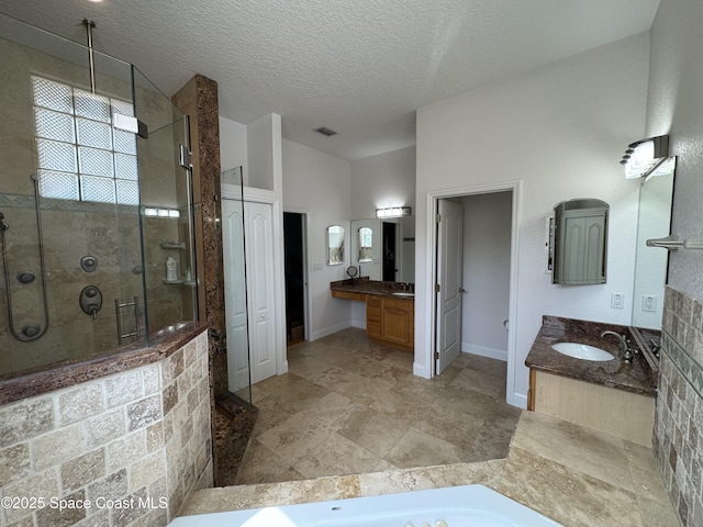 52 Riverview Ln, Cocoa Beach, FL 32931 - bathroom featuring a shower stall, vanity, a textured ceiling, and a bathtub