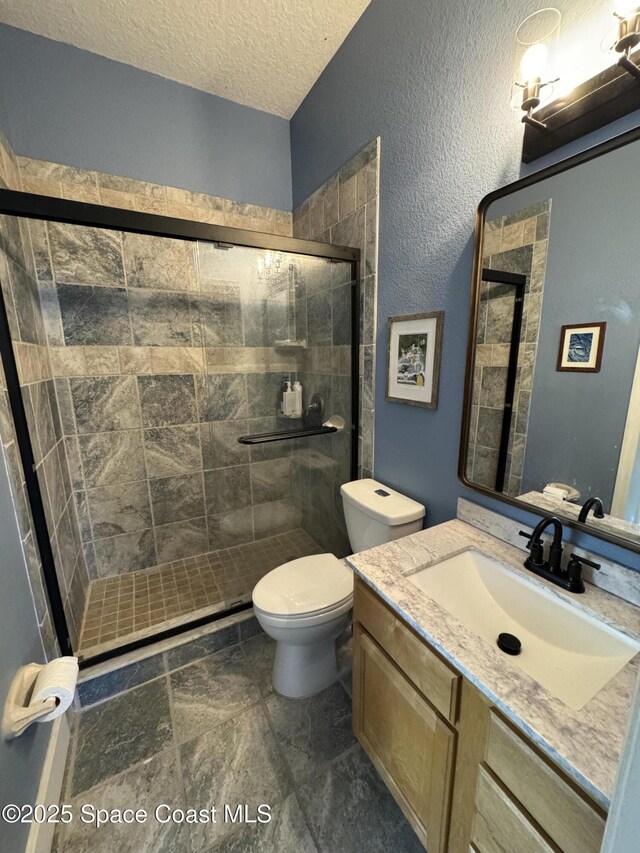 52 Riverview Ln, Cocoa Beach, FL 32931 - bathroom featuring vanity, a shower stall, a textured ceiling, and stone finish floors
