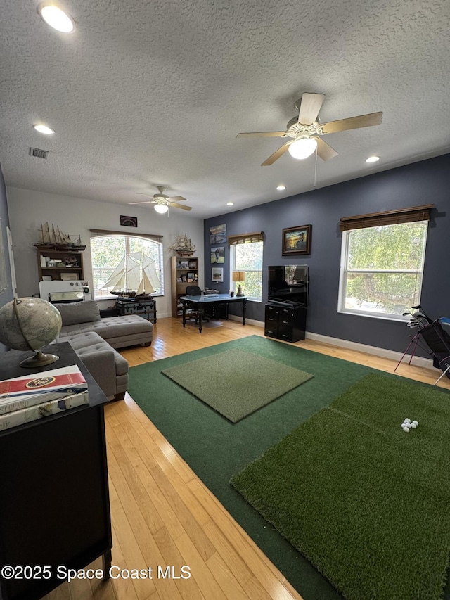 52 Riverview Ln, Cocoa Beach, FL 32931 - living room featuring a ceiling fan, a textured ceiling, healthy amount of natural light, light wood finished floors, and recessed lighting