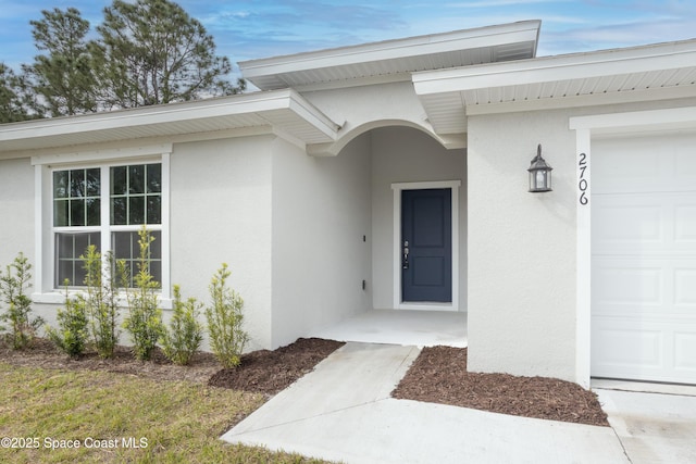 899 Brickell St SE, Palm Bay, FL 32909 - doorway to property with an attached garage and stucco siding