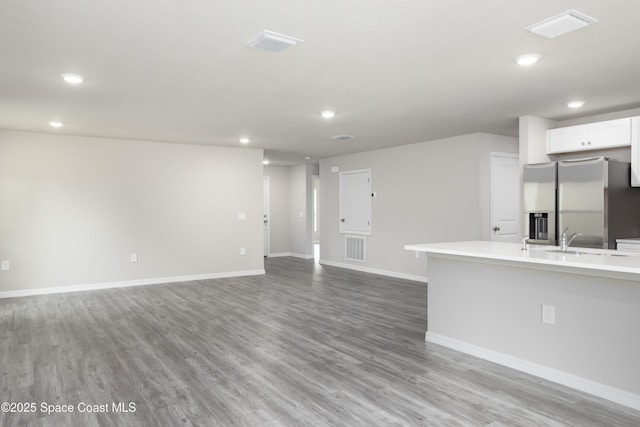899 Brickell St SE, Palm Bay, FL 32909 - kitchen featuring stainless steel fridge with ice dispenser, recessed lighting, light wood finished floors, light countertops, and white cabinets