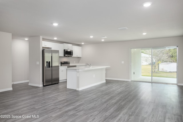 899 Brickell St SE, Palm Bay, FL 32909 - kitchen with stainless steel appliances, open floor plan, wood finished floors, recessed lighting, and white cabinets