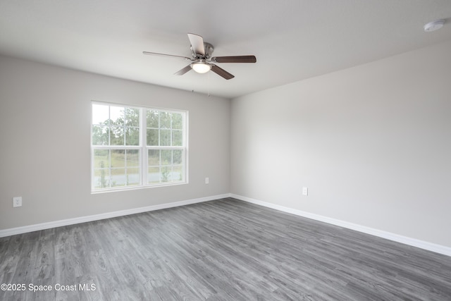 899 Brickell St SE, Palm Bay, FL 32909 - spare room with dark wood-style flooring, a ceiling fan, and a smoke detector