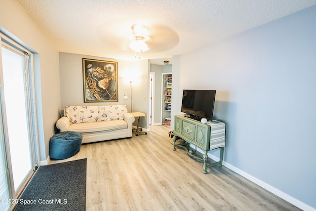 1139 Price Ave NW, Palm Bay, FL 32907 - living room with wood finished floors, a textured ceiling, a ceiling fan, and healthy amount of natural light