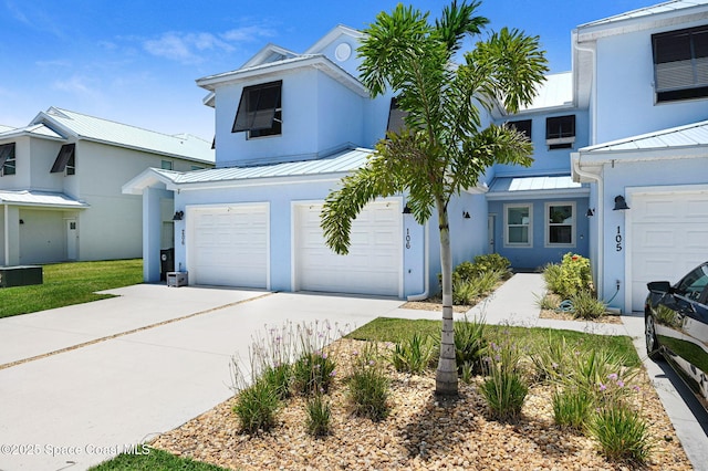 3930 Playa Del Sol Dr Unit 106, Rockledge, FL 32955 - view of front of house featuring stucco siding, a garage, concrete driveway, a standing seam roof, and a metal roof