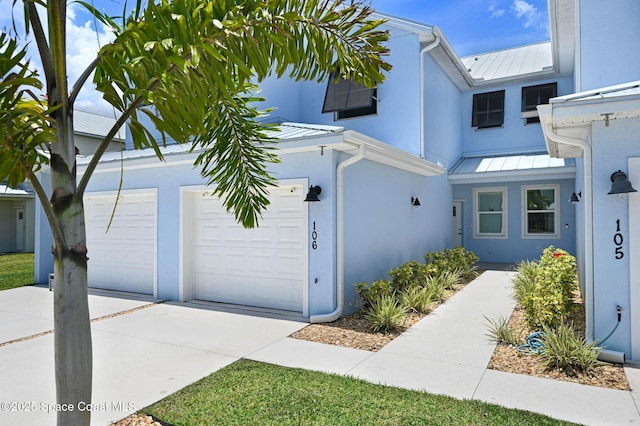 3930 Playa Del Sol Dr Unit 106, Rockledge, FL 32955 - view of front of property with a standing seam roof, stucco siding, and concrete driveway