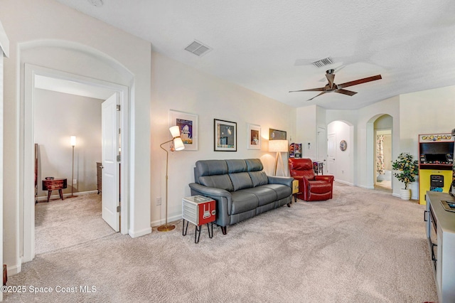 3930 Playa Del Sol Dr Unit 106, Rockledge, FL 32955 - carpeted living room with arched walkways and ceiling fan