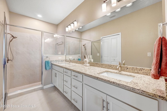 3930 Playa Del Sol Dr Unit 106, Rockledge, FL 32955 - bathroom with double vanity, a shower stall, tile patterned floors, and recessed lighting