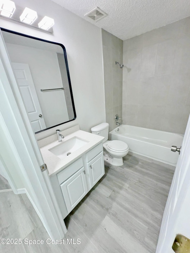 3162 San Salvador Ave, Palm Bay, FL 32909 - bathroom featuring vanity, a textured ceiling, wood finished floors, and shower / bathtub combination
