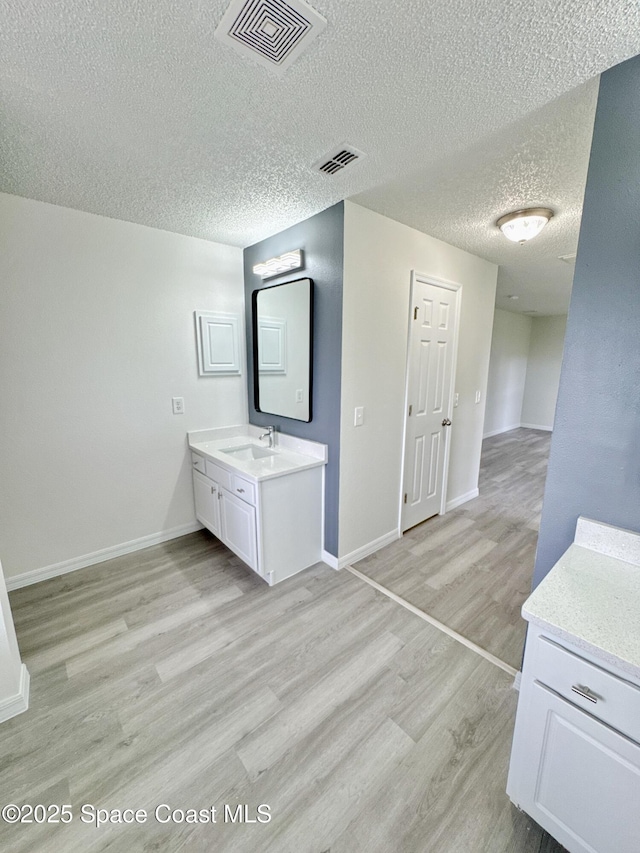 3162 San Salvador Ave, Palm Bay, FL 32909 - bathroom featuring a textured ceiling, vanity, and wood finished floors