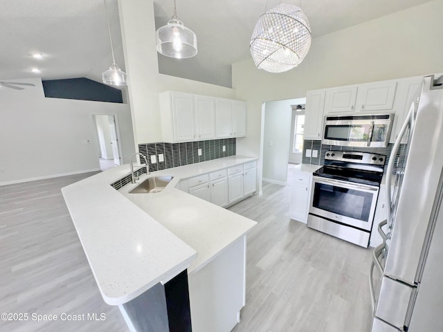 3162 San Salvador Ave, Palm Bay, FL 32909 - kitchen with stainless steel appliances, a peninsula, tasteful backsplash, white cabinetry, and light wood finished floors