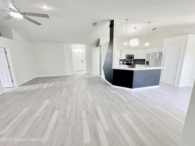3162 San Salvador Ave, Palm Bay, FL 32909 - unfurnished living room with lofted ceiling, ceiling fan, light wood finished floors, and a textured ceiling