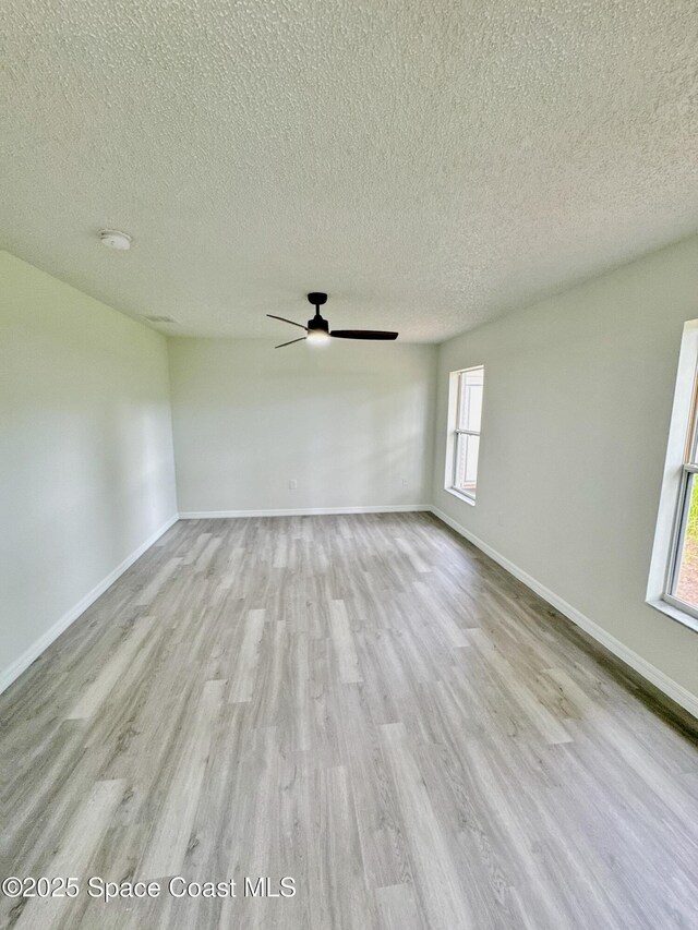 3162 San Salvador Ave, Palm Bay, FL 32909 - empty room featuring wood finished floors, a textured ceiling, ceiling fan, and a smoke detector
