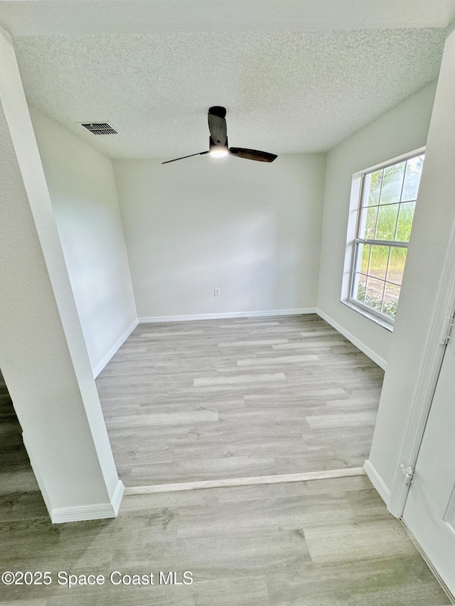 3162 San Salvador Ave, Palm Bay, FL 32909 - empty room with ceiling fan, wood finished floors, and a textured ceiling