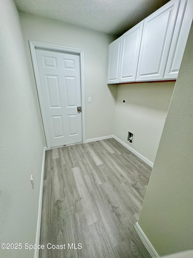 3162 San Salvador Ave, Palm Bay, FL 32909 - washroom featuring hookup for an electric dryer, cabinet space, light wood-type flooring, and a textured ceiling