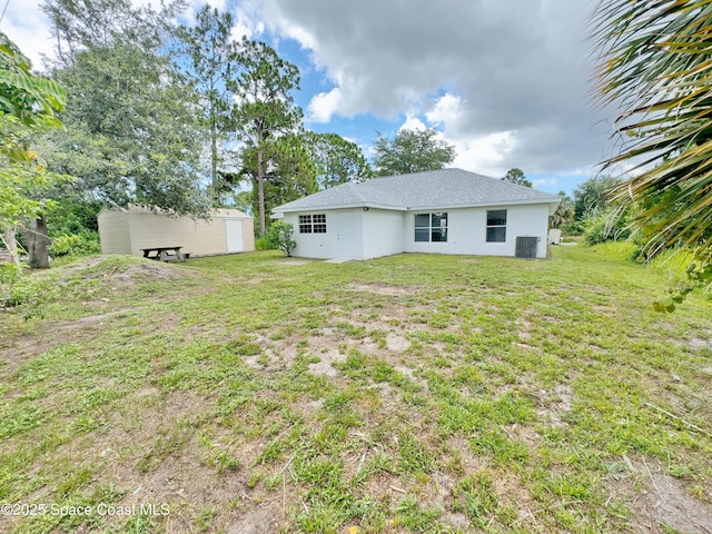 3162 San Salvador Ave, Palm Bay, FL 32909 - back of house featuring a lawn, stucco siding, and an outbuilding