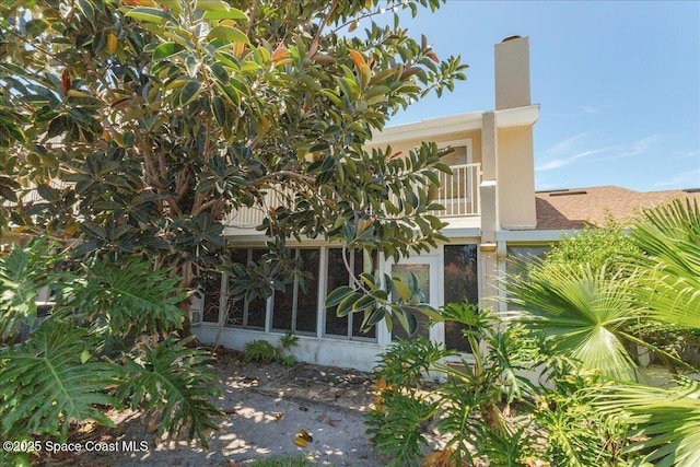 101 La Costa St Unit 2B, Melbourne Beach, FL 32951 - view of side of property featuring a chimney and a balcony