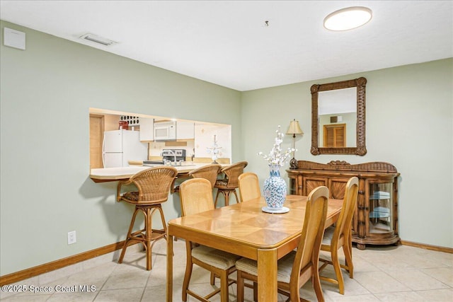 101 La Costa St Unit 2B, Melbourne Beach, FL 32951 - dining space featuring baseboards and light tile patterned floors