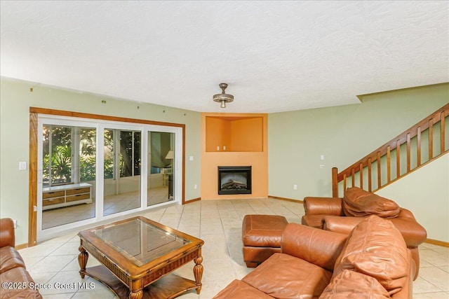 101 La Costa St Unit 2B, Melbourne Beach, FL 32951 - living room with light tile patterned floors, a textured ceiling, stairs, and a fireplace