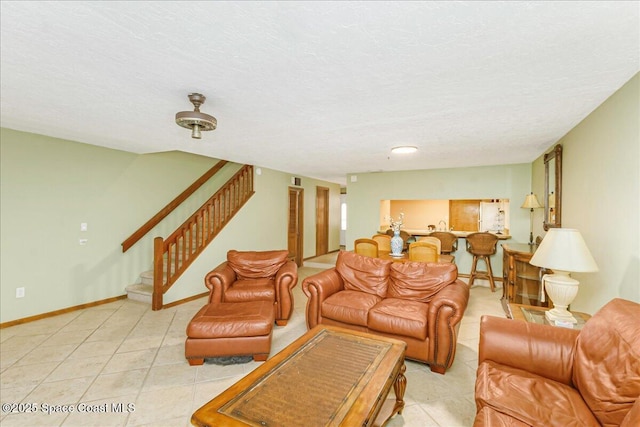 101 La Costa St Unit 2B, Melbourne Beach, FL 32951 - living area featuring light tile patterned floors, stairway, and a textured ceiling