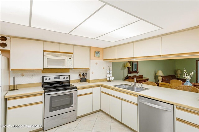 101 La Costa St Unit 2B, Melbourne Beach, FL 32951 - kitchen with stainless steel appliances, light countertops, decorative backsplash, and light tile patterned floors