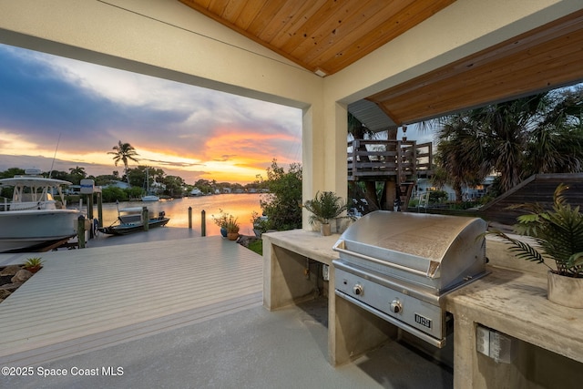 29 Azalea Dr, Cocoa Beach, FL 32931 - view of patio with a boat dock, a water view, and exterior kitchen