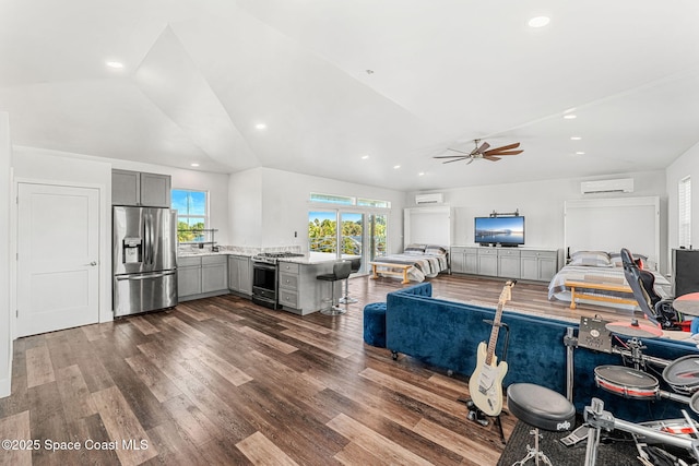 29 Azalea Dr, Cocoa Beach, FL 32931 - living area with dark wood-type flooring, vaulted ceiling, ceiling fan, recessed lighting, and a wall mounted air conditioner