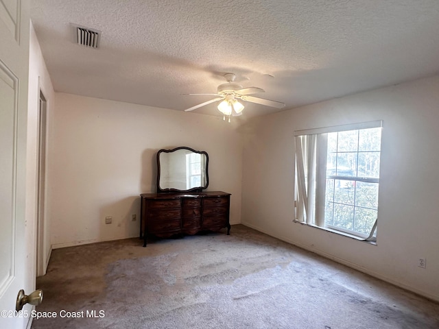 1765 Tatum Blvd, New Smyrna Beach, FL 32168 - unfurnished bedroom with a textured ceiling, carpet flooring, and ceiling fan