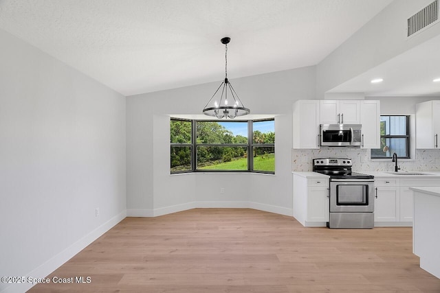 281 Caravan Ter, Sebastian, FL 32958 - kitchen with appliances with stainless steel finishes, light countertops, backsplash, a chandelier, and vaulted ceiling