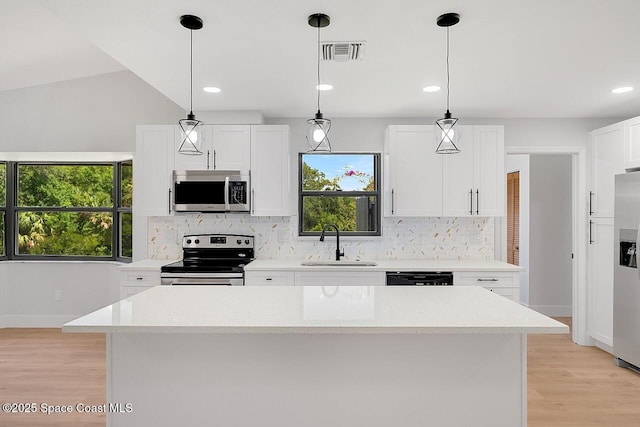 281 Caravan Ter, Sebastian, FL 32958 - kitchen featuring stainless steel appliances, tasteful backsplash, light wood finished floors, white cabinets, and recessed lighting