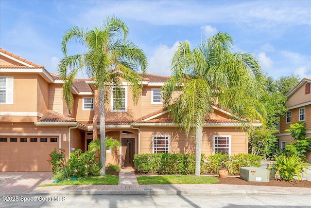 1390 Isabella Dr Unit 106, Melbourne, FL 32935 - townhome / multi-family property featuring an attached garage, a tile roof, driveway, and stucco siding