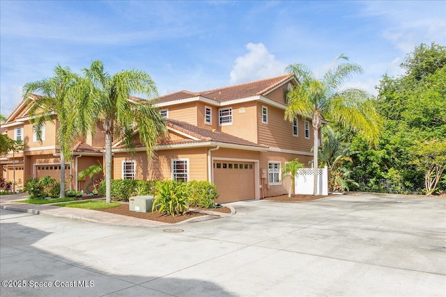 1390 Isabella Dr Unit 106, Melbourne, FL 32935 - view of front of property with a tile roof, driveway, a garage, and stucco siding
