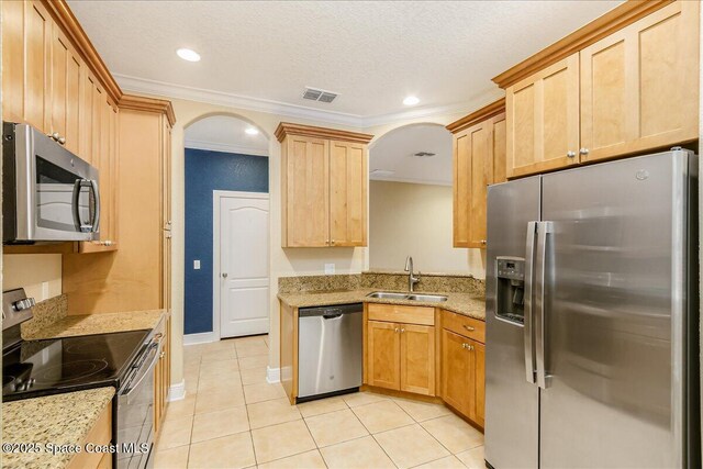 1390 Isabella Dr Unit 106, Melbourne, FL 32935 - kitchen featuring appliances with stainless steel finishes, arched walkways, light tile patterned floors, ornamental molding, and light stone counters