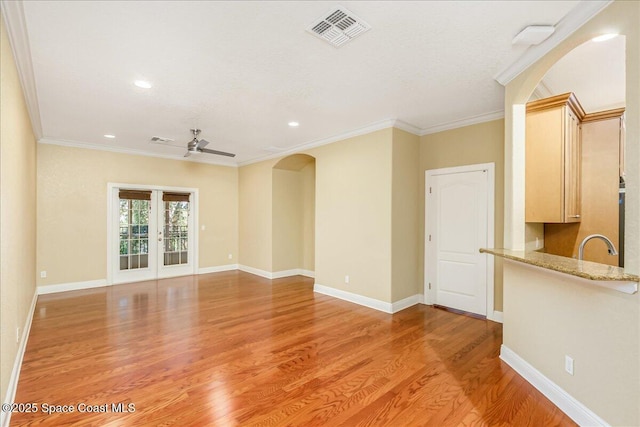 1390 Isabella Dr Unit 106, Melbourne, FL 32935 - unfurnished living room featuring light wood finished floors, arched walkways, crown molding, a ceiling fan, and recessed lighting