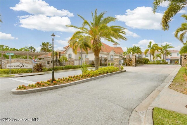 1390 Isabella Dr Unit 106, Melbourne, FL 32935 - view of asphalt street with curbs, street lights, a residential view, and a gated entry