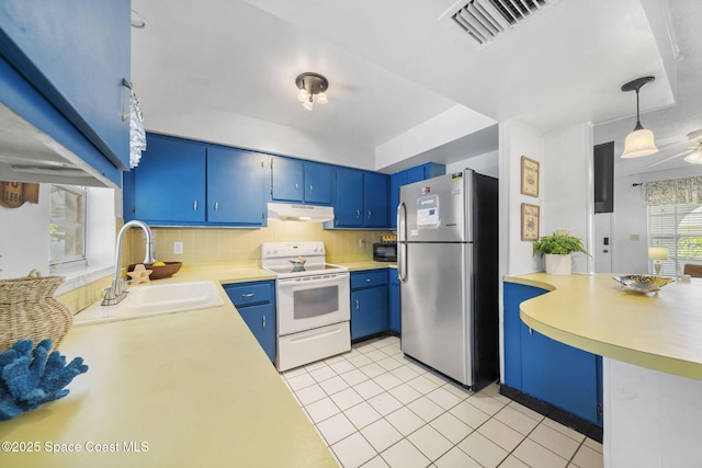 1242 Creel Rd NE, Palm Bay, FL 32905 - kitchen with white range with electric stovetop, freestanding refrigerator, under cabinet range hood, blue cabinets, and light countertops