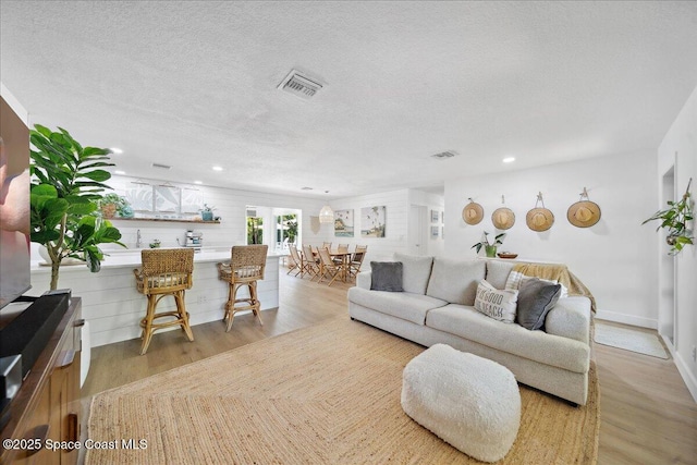 212 Ormond Dr, Indialantic, FL 32903 - living room with light wood finished floors, a textured ceiling, and recessed lighting