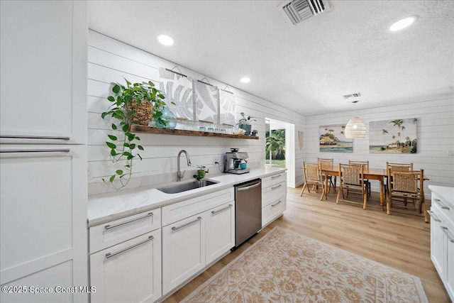 212 Ormond Dr, Indialantic, FL 32903 - kitchen with dishwasher, white cabinetry, light wood-type flooring, a textured ceiling, and recessed lighting