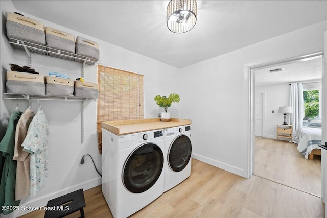 212 Ormond Dr, Indialantic, FL 32903 - washroom with independent washer and dryer, light wood-style flooring, and a chandelier