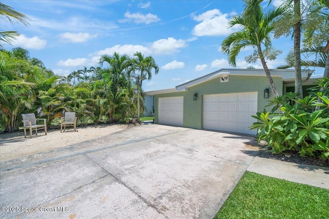 212 Ormond Dr, Indialantic, FL 32903 - view of front facade featuring stucco siding, a garage, and concrete driveway