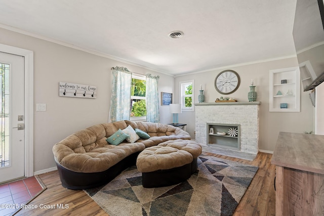 1949 36th Ave, Vero Beach, FL 32960 - living room featuring crown molding, wood finished floors, and a fireplace